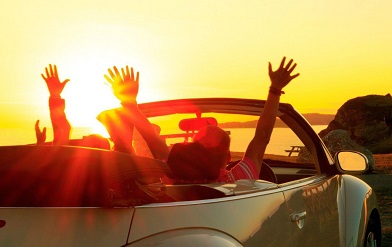 Estatic people driving in a cabrio.